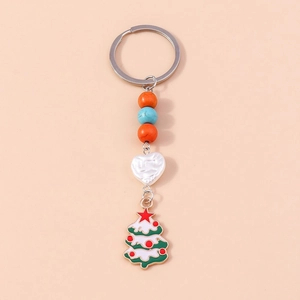 Close-up of a Christmas tree enamel pendant with colorful beads on a silver keychain