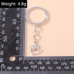 Detail view of a silver sun and cloud keychain on a ruler measuring 4.8g in weight