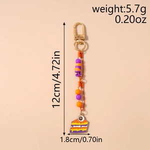 Detail of keychain featuring colorful cake enamel pendant with orange pin and size measurements