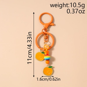 Détail montrant les dimensions du porte-clés orange avec breloques et étiquettes