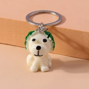 Detail view of a cute white resin dog keychain with green hair and silver metal ring