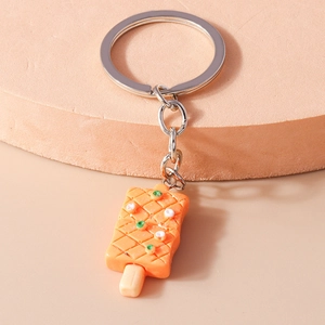 Gros plan détaillé d'un porte-clés en forme de glace orange avec perles de sucre déco