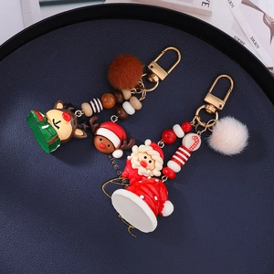 Detailed view of Christmas Santa and reindeer keychain with plush pompon and color beads
