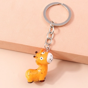 Detail of cute orange giraffe keychain with brown spots and shiny resin texture