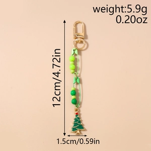 Detail view of a Christmas tree keychain with green beads and safety pins, 12cm long