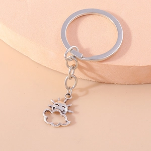 Detail of sun and cloud key ring charms in antique silver finish on a display block