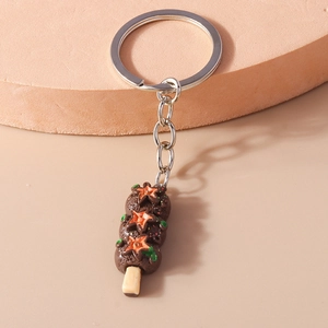Détail d'un pendentif créatif en chocolat avec des étoiles orange et un anneau de clé argenté