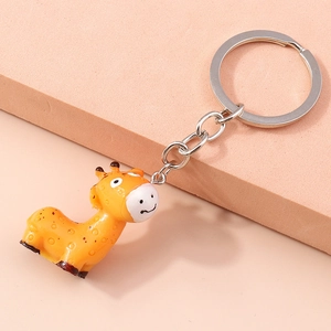 Detailed close-up of a cute yellow giraffe keychain on a soft pink background