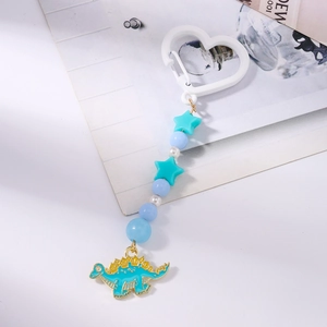 Détail du pendentif stégosaure bleu avec crochet coeur et perles colorées