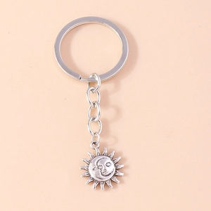 Macro view of vintage silver sun and moon keychain with detailed celestial face
