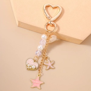 Détail du porte-clés étoile de mer rose et perle cœur avec breloques coquillage