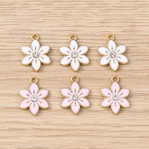 Detail view of 6-piece flower charms set with pink and white enamel and zircon center