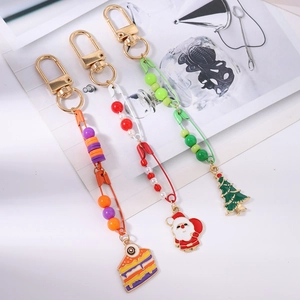 Close-up of festive Christmas tree and Santa Claus themed beaded keychains in gold finish