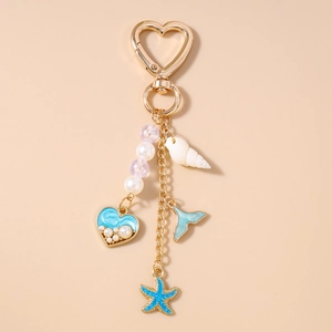 Détail d'un porte-clés thème océan avec pendentifs étoile de mer, coquillage et sirène
