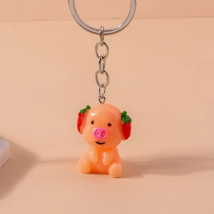 Close-up of cute orange pig keychain with strawberry ears and silver metal ring chain