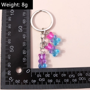 Macro shot of colorful resin gummy bears keychain with ruler showing 8g weight and 20mm size