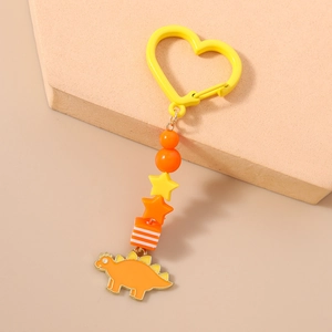 Détail du porte-clés dinosaure orange avec clip en forme de cœur et perles colorées