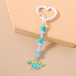 Détail du porte-clés dinosaure avec clip coeur bleu et pendentif stégosaure en émail
