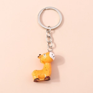 Close-up of a cartoon giraffe keychain with bright orange resin and silver metal ring