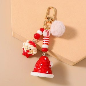 Macro detail of Christmas keychain featuring Santa Claus, plush ball, and golden clip