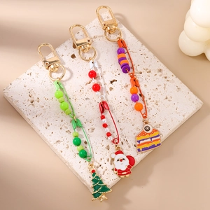 Detailed macro view of Christmas tree, Santa, and cake charm keychains with resin beads