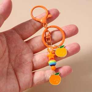 Gros plan de breloques orange et perles d'étoile de mer sur un porte-clés à fermoir