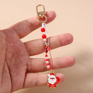 Close-up of a Christmas keychain with red beads and Santa Claus enamel charm