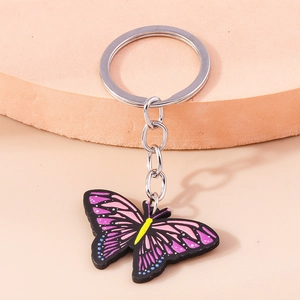Detail eines lila Schmetterling-Schlüsselanhängers auf einem rosa gestuften Ständer