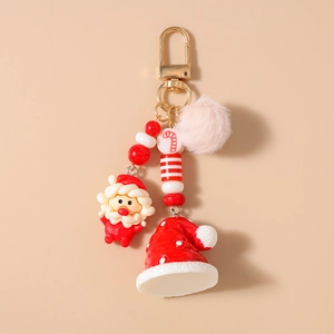 Detailed view of Christmas keychain with plush pompom, Santa charm, and golden metal hook