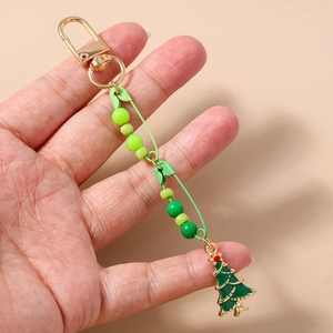 Detail showing a golden clasp with gradient green beads and enamel Christmas tree charm