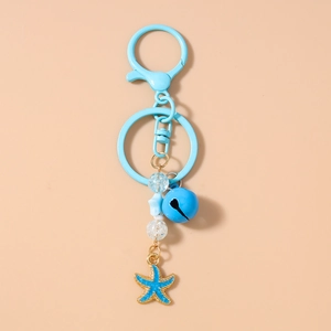 Détail de porte-clés étoile de mer bleue avec breloques perlées et cloches marines