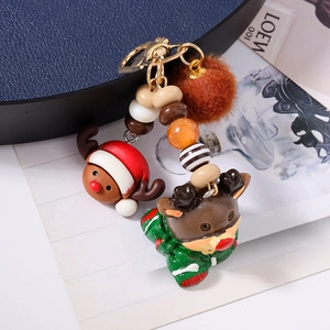 Detail of Christmas reindeer keychain with red hat, plush pompom and gold clasp