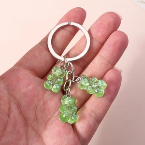 Macro shot of silver keyring with three translucent green resin bear charms and glitter