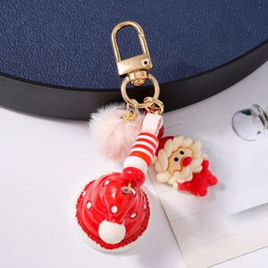 Close-up of Santa Claus keychain with pink plush pompom and gold metal clasp