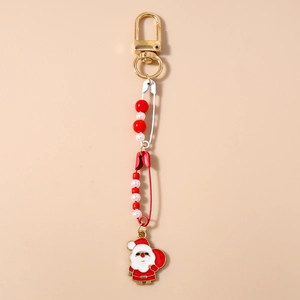 Detail view of a Christmas Santa Claus keychain with festive red beads and gold safety pin