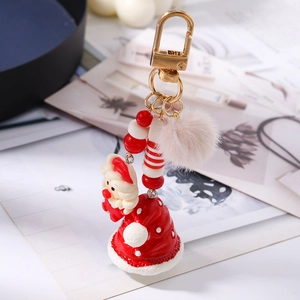 Close-up of Santa Claus keychain with red hat, plush pompom and festive bead strand