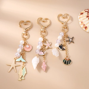Detailed close-up of ocean-themed keychains featuring starfish, shell, and whale charms