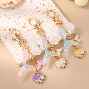 Detail of mermaid tail keychain featuring gradient fish scales, resin shell and faux pearls