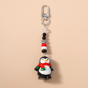 Détail d'un porte-clés pingouin mignon avec écharpe rouge et chaîne de perles colorées