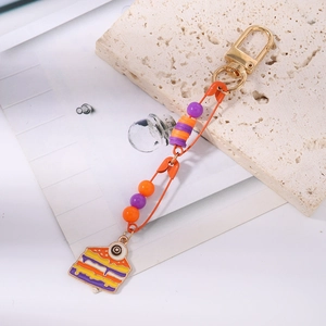 Macro detail of quirky safety pin keychain featuring beads and eyeball cake charm
