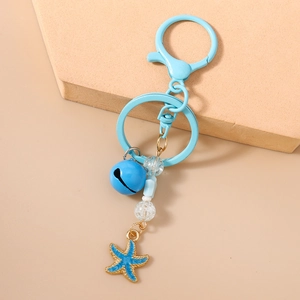Détail d'un porte-clés bleu sur le thème marin avec breloque étoile de mer et fermoir doré