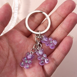 Close-up of three purple glitter resin bear charms on a silver metal keychain