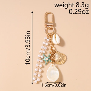 Detailed view of ocean theme keychain with gold starfish, pearl tassel and seashell charm
