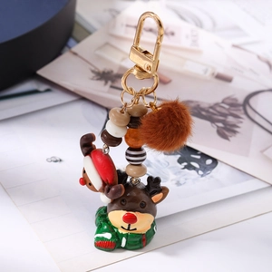 Detail of Christmas reindeer keychain with plush pom-pom, beads and golden lobster clasp