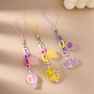 Close-up of cute Saturn, butterfly and candy charms with colorful links for bags or keys