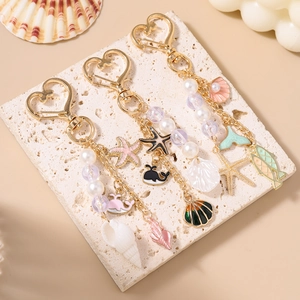 Detailed shot of ocean-themed beaded keychains with gold heart clasps and shells