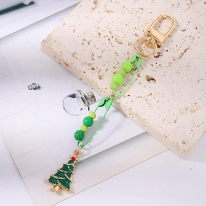 Detail of Christmas tree keychain with green enamel pendant and golden lobster clasp