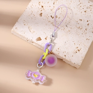 Close-up of a purple candy pendant with a yellow heart on a chunky plastic chain link