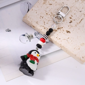 Détail du porte-clés pingouin mignon avec perles colorées et écharpe rouge festive