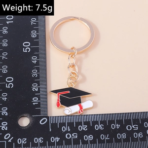 Vue détaillée du porte-clés chapeau de diplômé avec pompon rouge et charme de diplôme